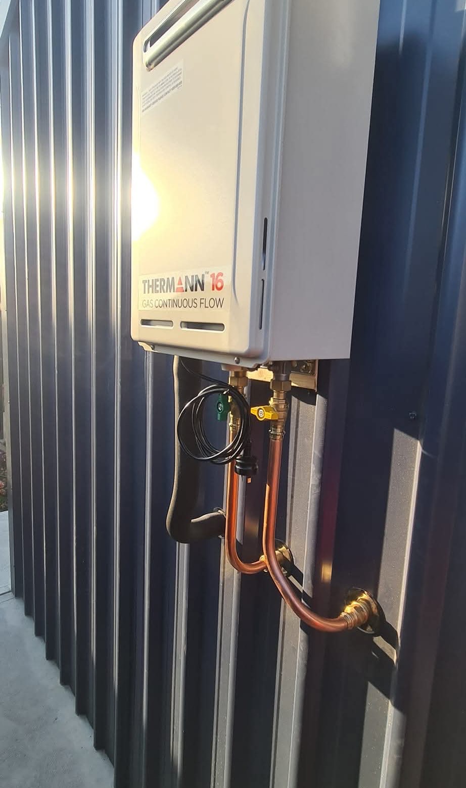 Completed Thermann continuous-flow hot-water installation with visible copper pipework