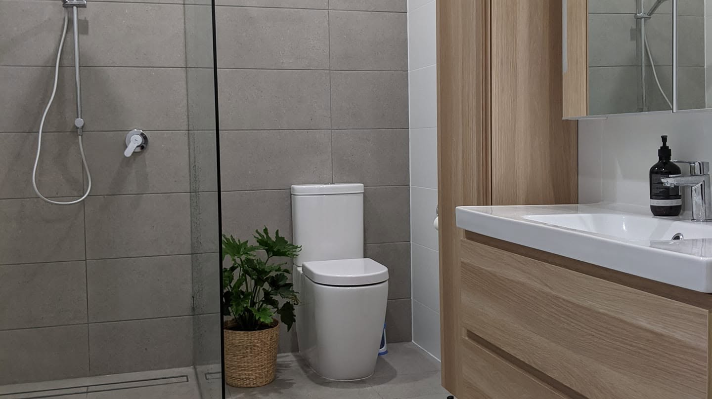 Finished Coastline Built bathroom with a walk-in shower, timber vanity and grey tiling
