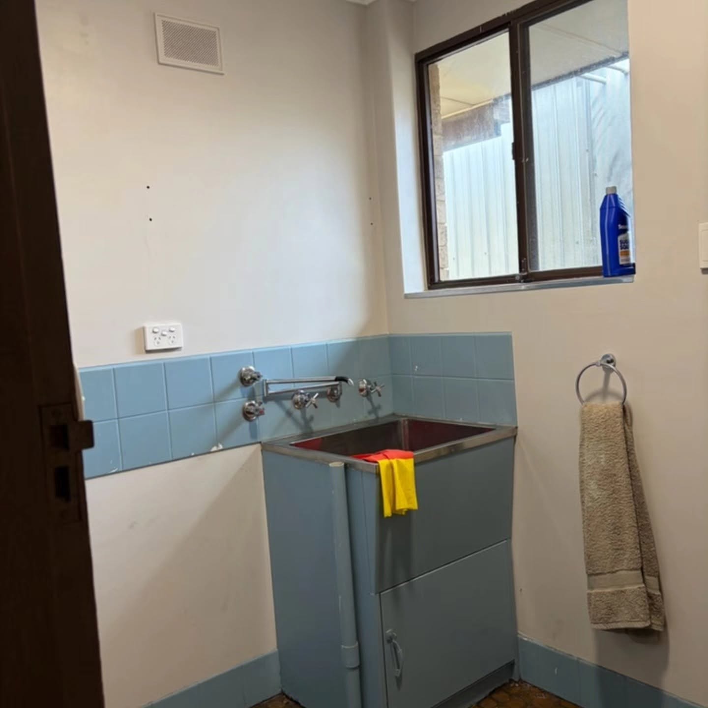Laundry before renovation with original blue cabinetry and splashback
